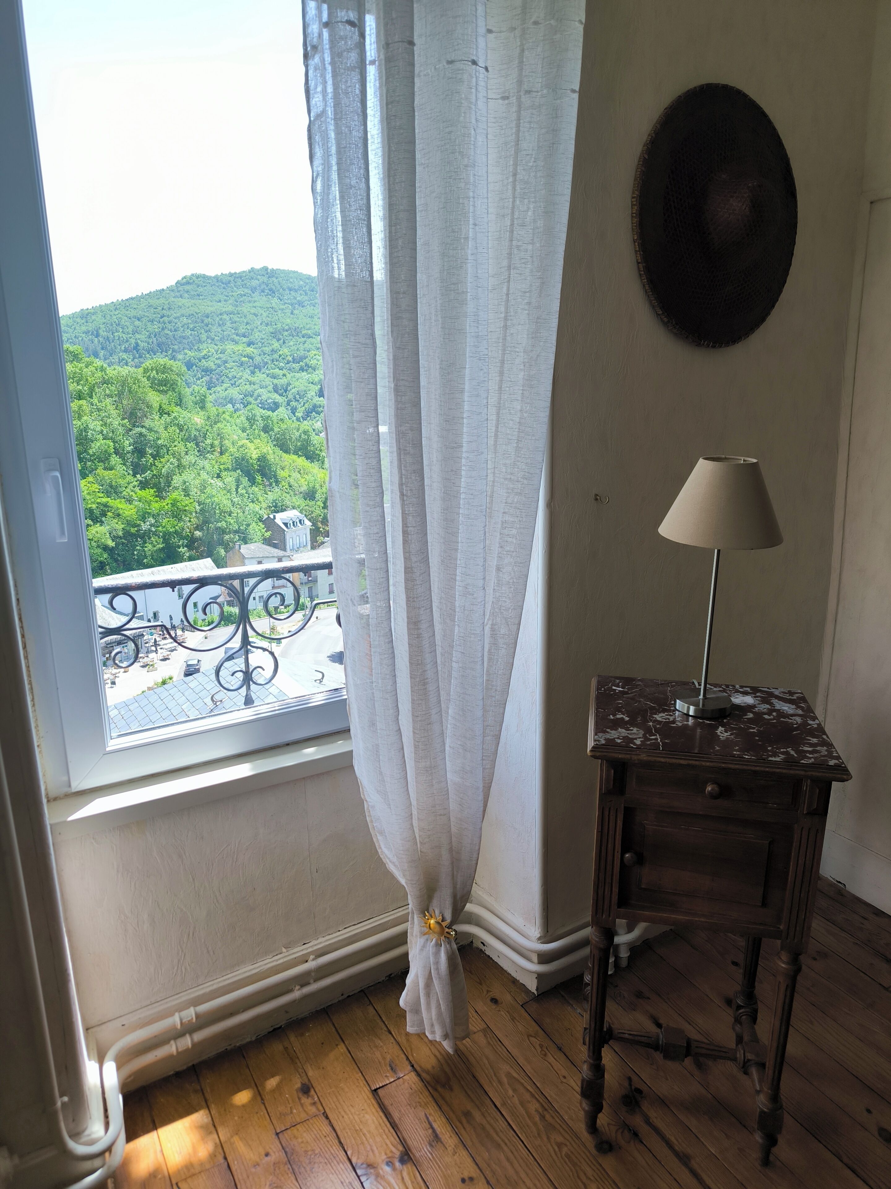 Ein Zimmer mit Fenster, Vorhang, Lampe und einer Wandtafel.