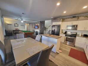 Enjoy meals and games in the spacious dining area with a pool table and comfortable seating.