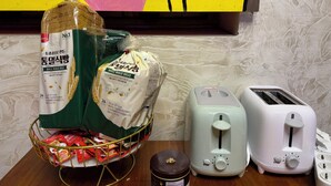 A kitchen counter with a bread basket, two toasters, and a jar of honey. - Maison Yongsan Hotel (Seoul)