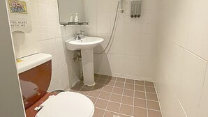A small, compact bathroom with a white sink, a toilet, and a shower. - Maison Yongsan Hotel (Seoul)