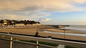 Une vue sur la côte, avec une plage, une jetée et des immeubles d’habitation.