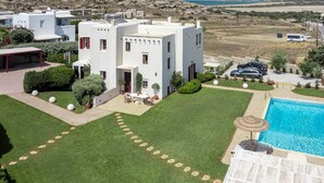 Een moderne villa met zwembad, een verzorgd gazon en uitzicht op het omliggende landschap.