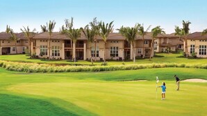 A golf course with a clubhouse and palm trees. - Vintage tropical townhouse close to pool Colony Villas Bldg 28 (Waikoloa)