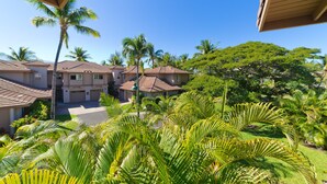 A residential area with multiple houses, palm trees, and a clear blue sky. - Vintage tropical townhouse close to pool Colony Villas Bldg 28 (Waikoloa)