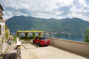 A red car parked on a balcony with a mountain view. - Luxury Convent-Finnish Wooden Jacuzzi/LakeViews/AC (Cernobbio)