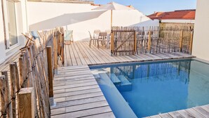 A wooden deck with a pool, outdoor furniture, and a bamboo fence. - Villa Zanzibar - 80m from the beach with pool (Mimizan)