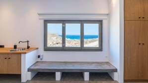 Eine Küche mit eingebauter Bank, einem Fenster mit Meerblick und Holzschränken.