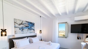 Ein modernes Hotelzimmer mit einem großen Bett, einem Flachbildfernseher, einem Schreibtisch und einem Fenster mit Blick auf die Wüste.