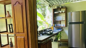 Una cocina con armarios de madera, un refrigerador de acero inoxidable y una encimera con varios utensilios de cocina.