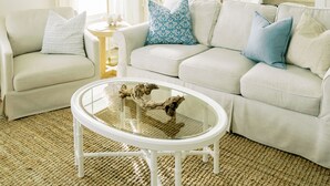 A living room with a white sofa, a glass coffee table, and a ceiling fan. - Family Friendly House - Resort Style Amenities & Baby Gear (Beaufort)