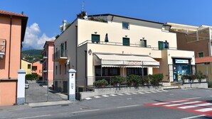 Un immeuble avec un café au rez-de-chaussée, une entrée bien visible et un ciel dégagé.