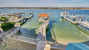 Un port de plaisance doté de plusieurs quais, d’une jetée centrale menant à une structure abritée, et offrant une vue dégagée sur l’eau environnante et la côte lointaine.