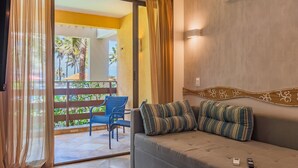 A room with a sofa, two striped pillows, a remote control, and a smartphone on the sofa. - Apart no Beach Park Suítes por Carpediem (Aquiraz)