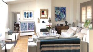 A spacious living room with a high ceiling, a fireplace, and a large abstract painting. - 500 m from Roland Garros stadium, apartment with terrace (6-8 people) (Boulogne-Billancourt)