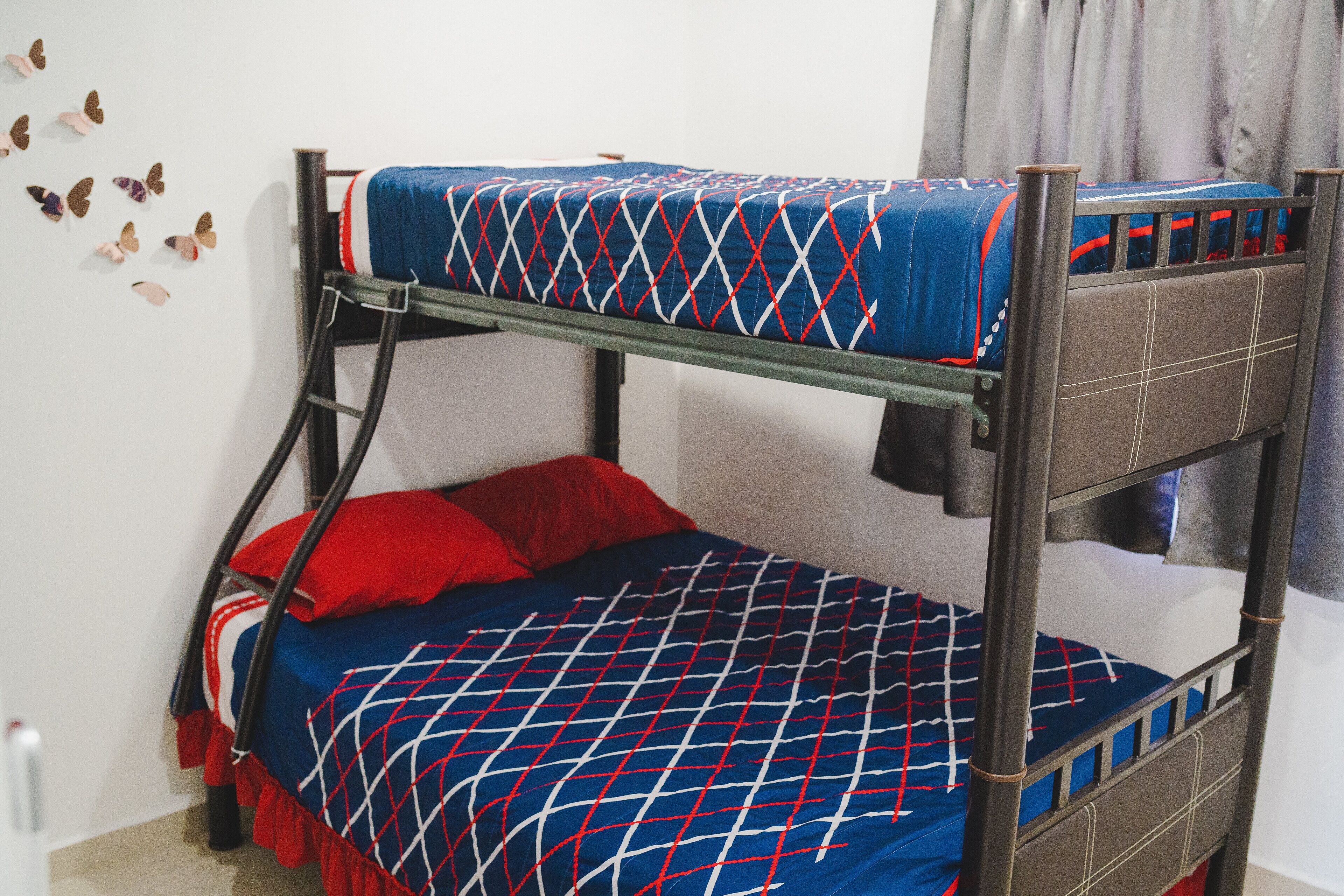 A bunk bed with a patterned bedspread and red pillows.