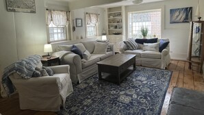 A living room with a sofa set, a coffee table, and a patterned rug. - Large Charming Historic House close to Beaches (Clinton)