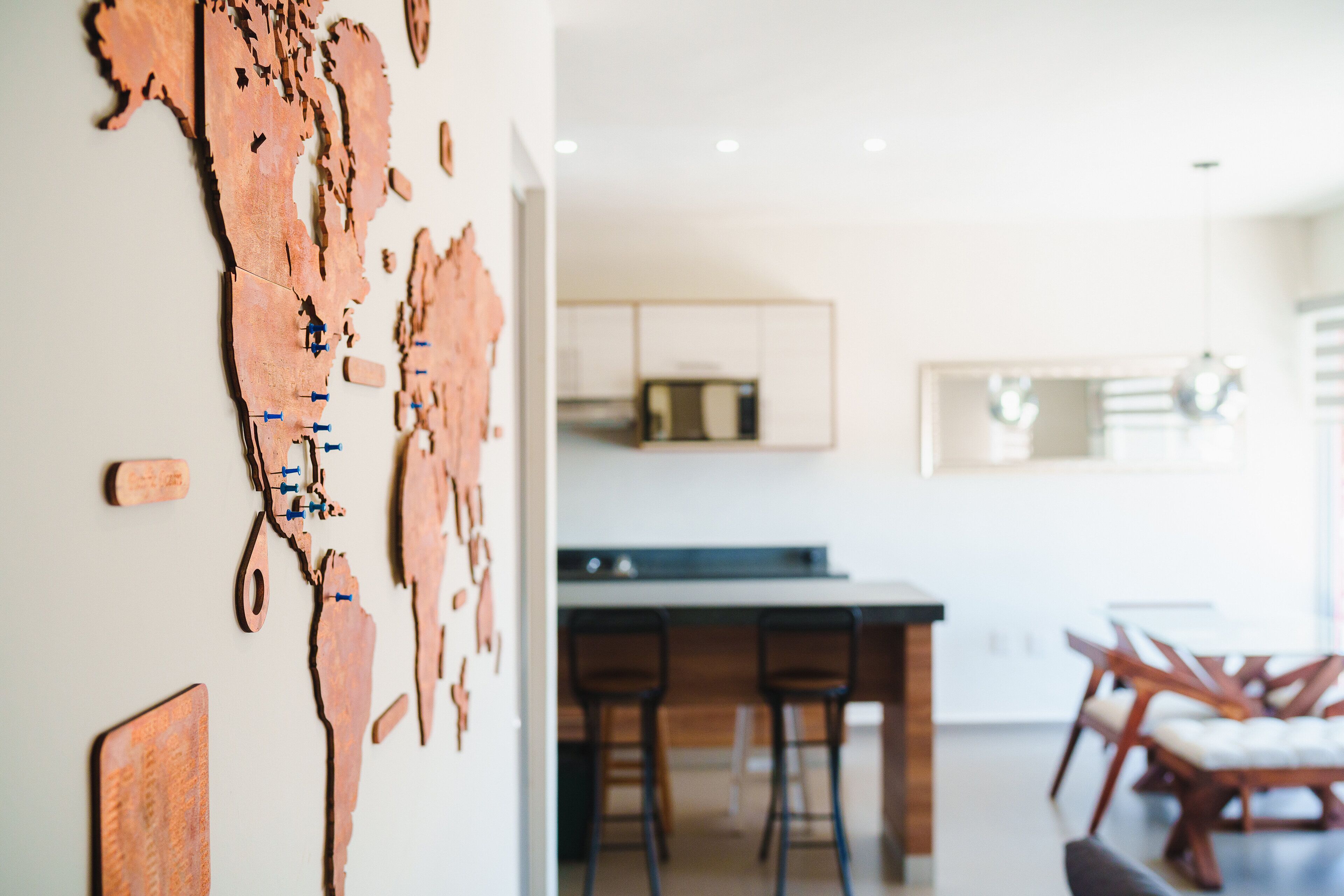 Una cocina moderna con una isla central, taburetes de bar y una mesa de comedor con sillas.