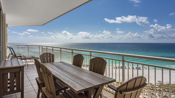 A wooden table and chairs on a balcony overlooking a beach with a clear view of the ocean and sky. - Beachfront - Sugar white sand right at your doorstep (Navarre)