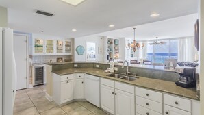 A modern kitchen with white cabinets, a granite countertop, and a built-in dishwasher. - Beachfront - Sugar white sand right at your doorstep (Navarre)