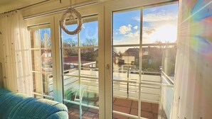 Une pièce dotée d’une grande porte-fenêtre coulissante donnant sur un balcon.