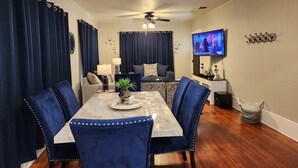 A dining area with a table, chairs, and a ceiling fan.