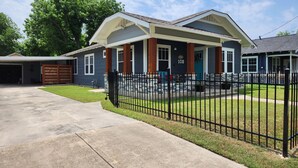 A two-story house with a front porch, a garage, and a well-maintained lawn.