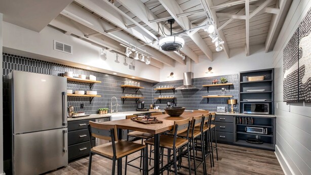 A modern kitchen with a central island, bar stools, and built-in appliances.