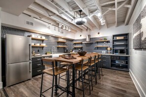 A modern kitchen with a central island, bar stools, and built-in appliances. - Skyline Penthouse 6BR/4,400 sq ft Walk to Broadway (Nashville)