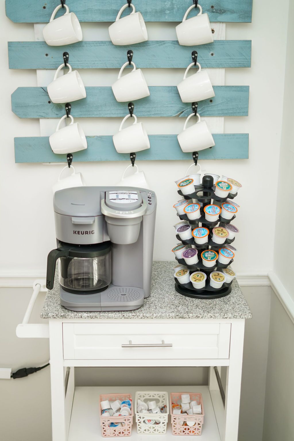 A coffee station with a Keurig coffee maker and a dispenser of coffee pods.