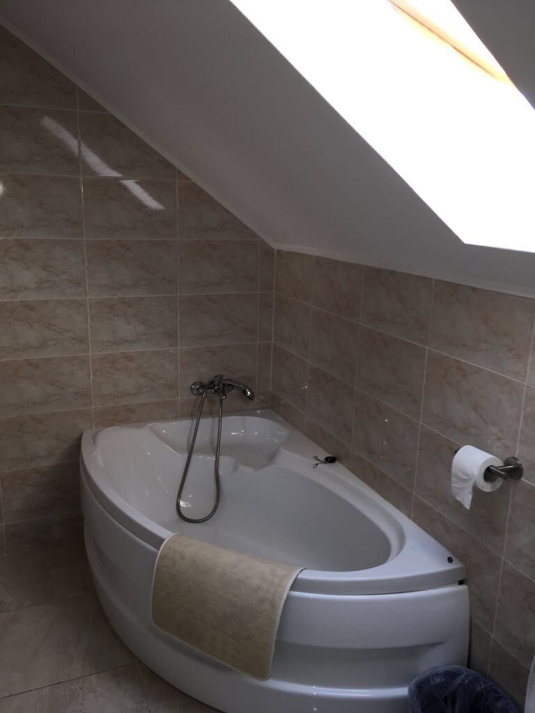 A modern bathroom with a freestanding bathtub, a towel rack, and a toilet.