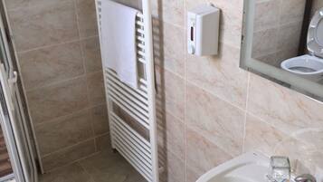 Un baño con un lavamanos blanco, un perchero y un espejo.
