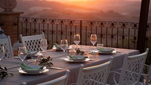 A table set for a meal with a view of the sunset over a mountainous landscape. - VILLA BELLAVISTA-TUSCANY-POOL -JACUZZI- breath-taking view-great for family (Toscana)