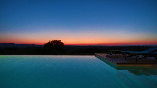 A swimming pool with lounge chairs and a sunset view. - VILLA BELLAVISTA-TUSCANY-POOL -JACUZZI- breath-taking view-great for family (Toscana)