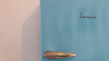 A light blue vintage refrigerator with the brand name "Lom" on the top.