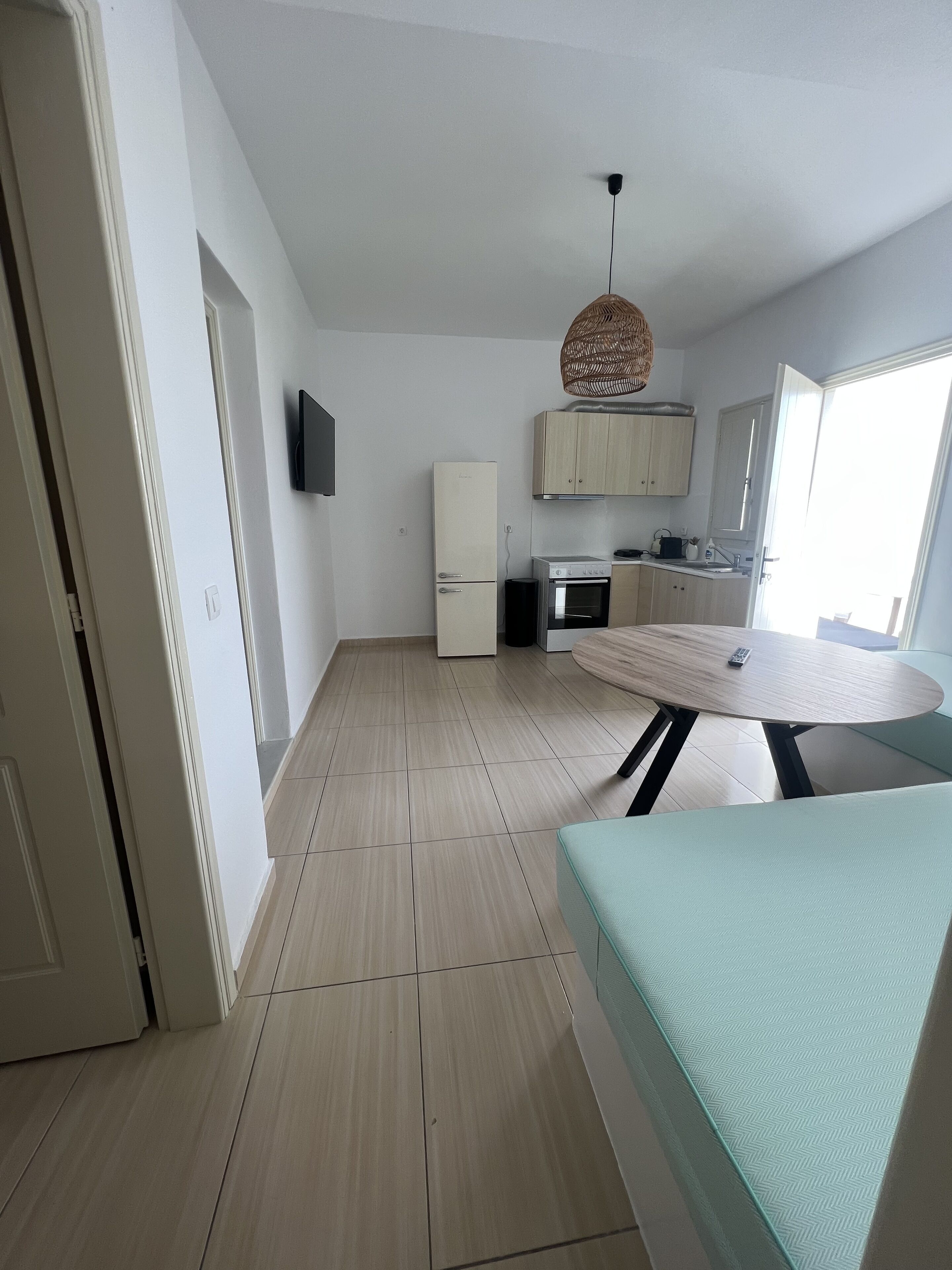 A modern kitchen with a refrigerator, stove, and wooden cabinets.