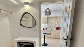 Una cocina compacta con comedor, un espejo y una lámpara colgante.