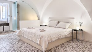 Un dormitorio con una cama grande, una mesita de noche y un aplique.