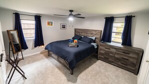 A bedroom with a bed, dresser, and an easel. - Family & Pet Friendly Smart Home, Garage Parking, Fenced Yard, Near Stadiums (Euless)
