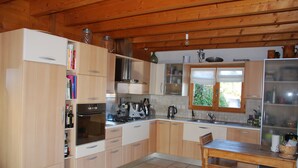 Una cocina con armarios de madera, una estufa y una mesa de comedor.