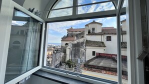A room with a large arched window overlooking a historic town with traditional buildings. - Casa Diodora, vicino al mare, in Costiera Amalfitana (Maiori)