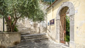 A stone staircase leading to a building with a wrought iron gate. - Casa Diodora, vicino al mare, in Costiera Amalfitana (Maiori)