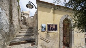 A narrow stone staircase leading to a building with a tiled roof and a metal gate. - Casa Diodora, vicino al mare, in Costiera Amalfitana (Maiori)