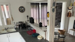 A compact kitchen with a washing machine, a coffee maker, and a sink.