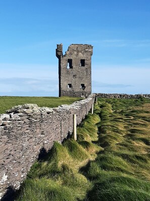 A stone tower with multiple openings, surrounded by a stone wall and grassy terrain. - 5-star rural escape hidden between the coastal towns of Kinsale and Clonakilty, (Clonakilty)