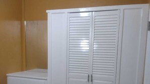 A bedroom with a bed, a wardrobe, and a nightstand. - La Bwizan Inn Apt. #1 (Laborie)