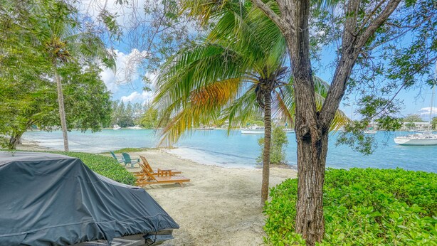 A beach with a covered area, a boat, and a clear view of the water. - Relaxation (Montego Bay)