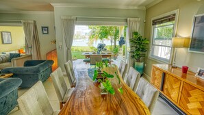 A spacious dining area with a wooden table, chairs, and potted plants. - Relaxation (Montego Bay)