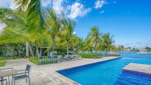 A swimming pool with lounge chairs and palm trees. - Relaxation (Montego Bay)