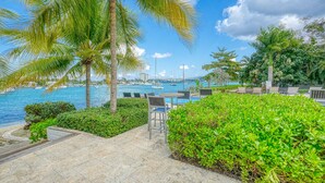 A poolside area with palm trees, a view of the sea, and a few chairs. - Relaxation (Montego Bay)