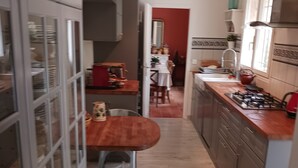 Una cocina con armarios, una mesa de comedor y una estufa.